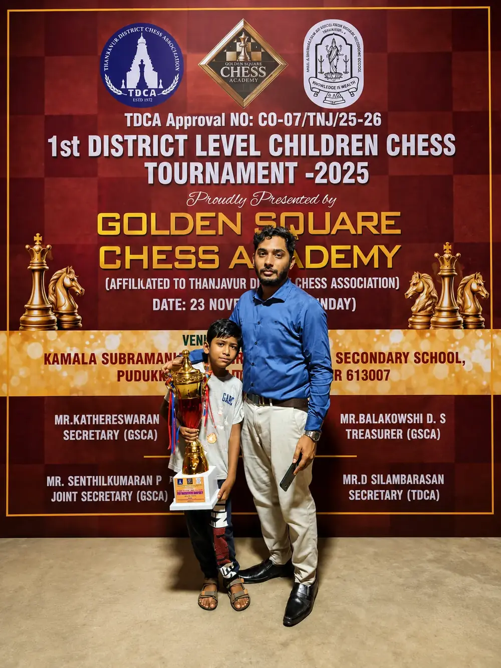 Nine young players holding trophies and certificates after a chess tournament in Thanjavur